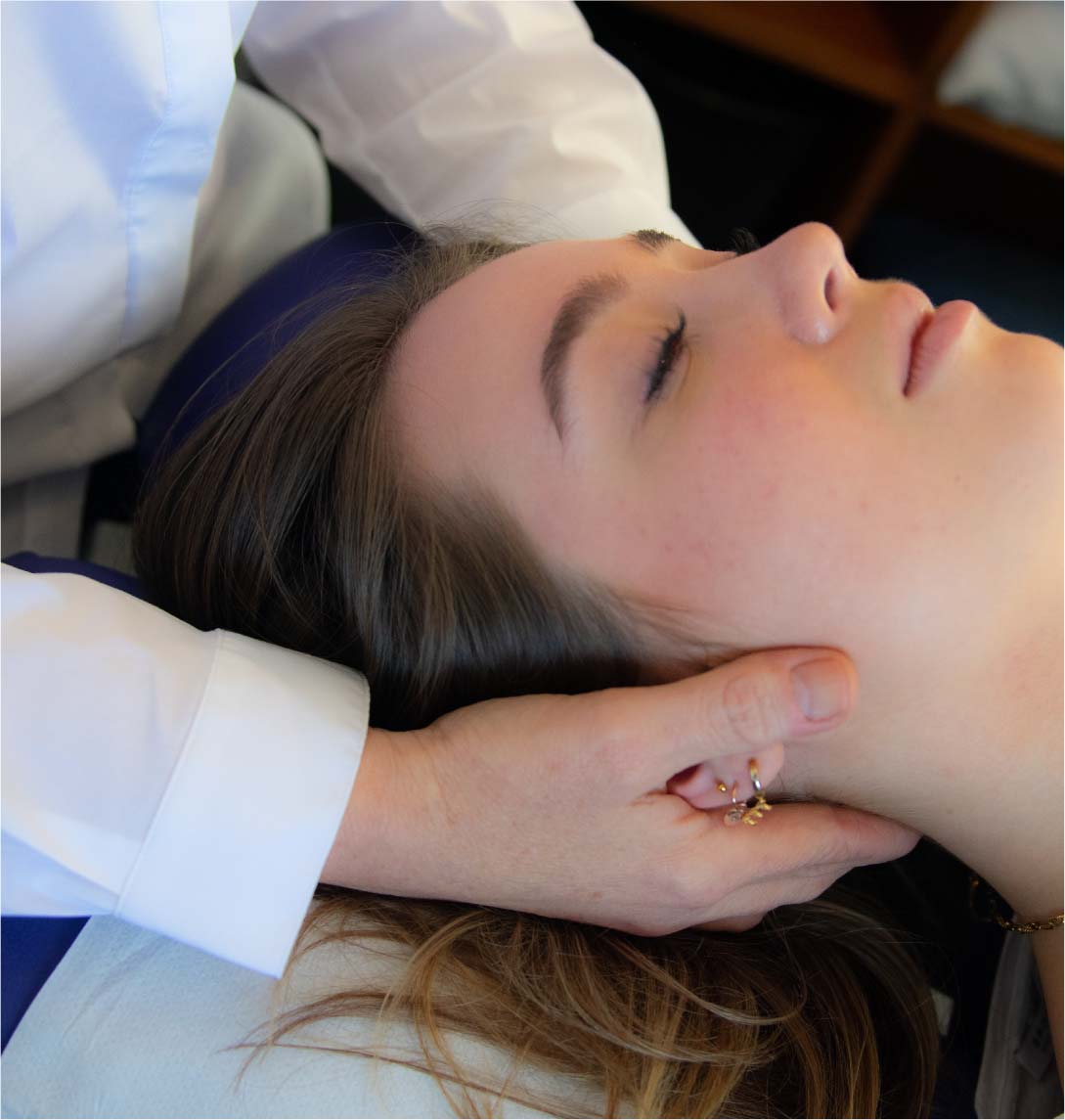 Craniosacral therapy with Dr Kates hands placed under the patients neck and tension area